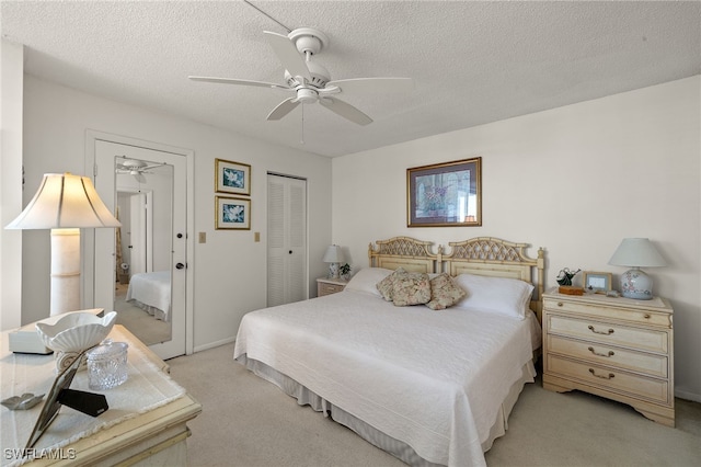 bedroom with a closet, light carpet, a textured ceiling, and ceiling fan