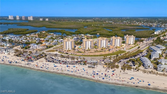 drone / aerial view featuring a city view, a view of the beach, and a water view