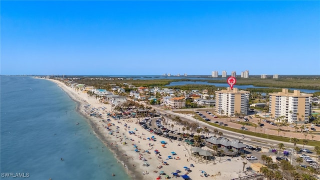 drone / aerial view featuring a view of city, a beach view, and a water view