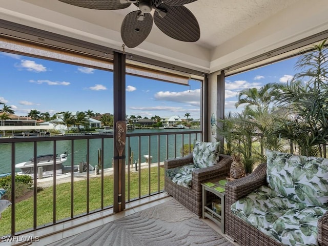 sunroom with a water view and a ceiling fan