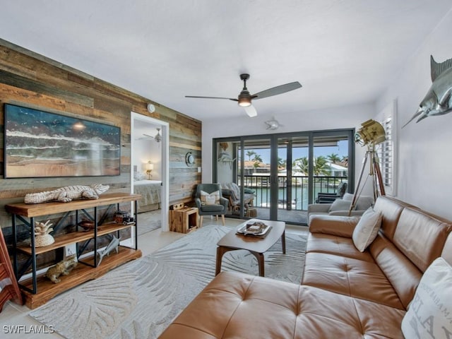 living area with wood walls and ceiling fan