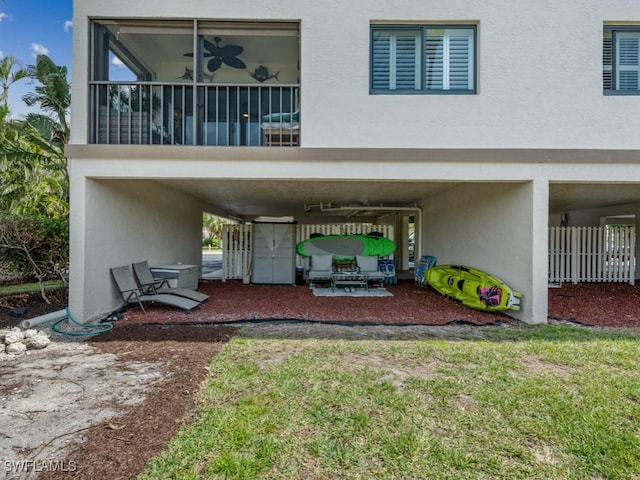 rear view of house featuring a carport and stucco siding