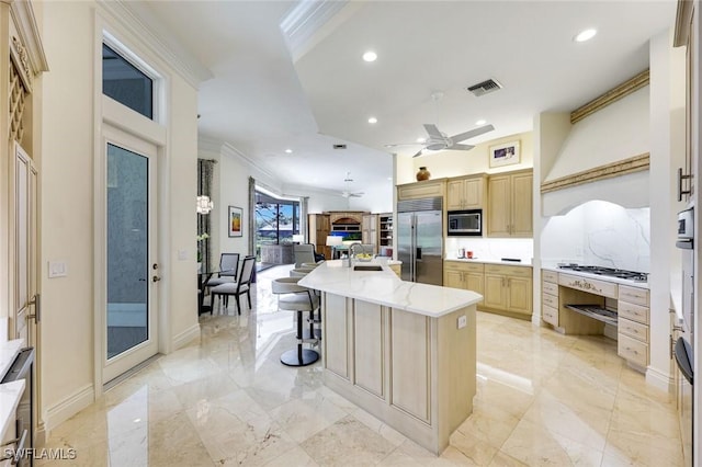 kitchen featuring built in appliances, light brown cabinets, visible vents, marble finish floor, and ornamental molding