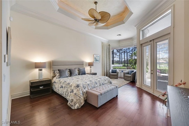 bedroom featuring crown molding, a tray ceiling, dark wood finished floors, and access to exterior