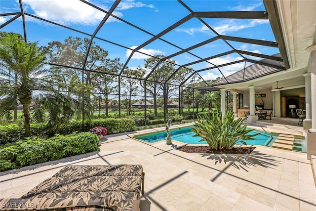 pool with a ceiling fan, glass enclosure, and a patio