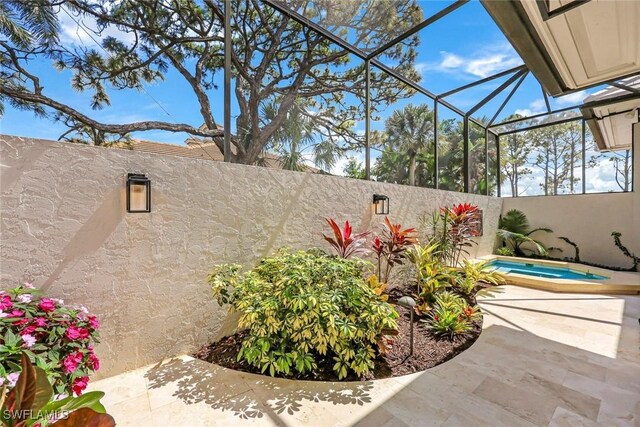 view of patio featuring a lanai, a fenced backyard, and a hot tub