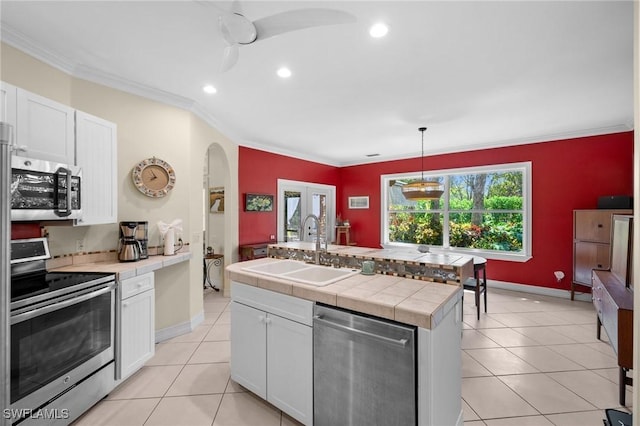 kitchen featuring stainless steel appliances, white cabinets, crown molding, and a sink