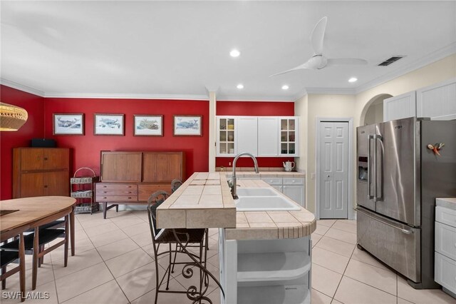 2440 River Reach Dr, Naples, FL 34104 - kitchen with tile counters, visible vents, light tile patterned floors, a sink, and stainless steel fridge