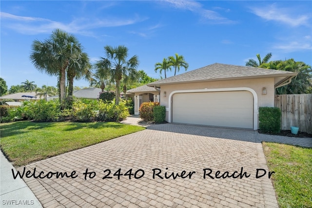 single story home with stucco siding, an attached garage, fence, decorative driveway, and a front yard