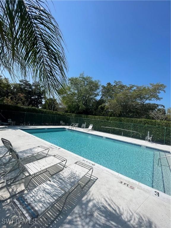 pool with a patio area and fence