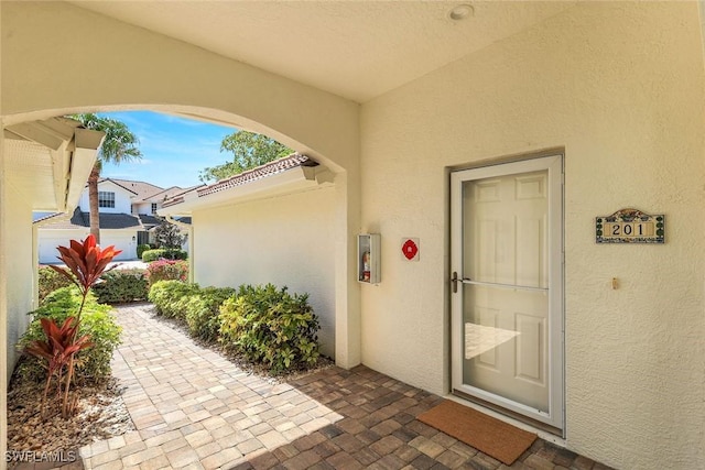 entrance to property with a patio area and stucco siding