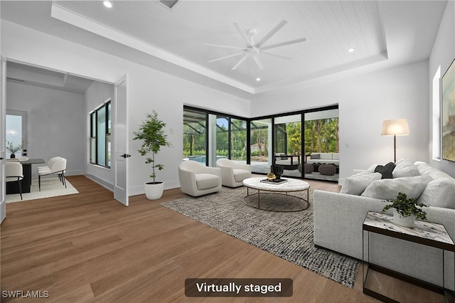 3233 64th St SW, Naples, FL 34105 - living area featuring a tray ceiling, ceiling fan, wood finished floors, and recessed lighting