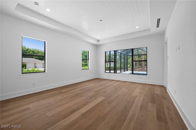3233 64th St SW, Naples, FL 34105 - unfurnished room with a tray ceiling, wood finished floors, and recessed lighting