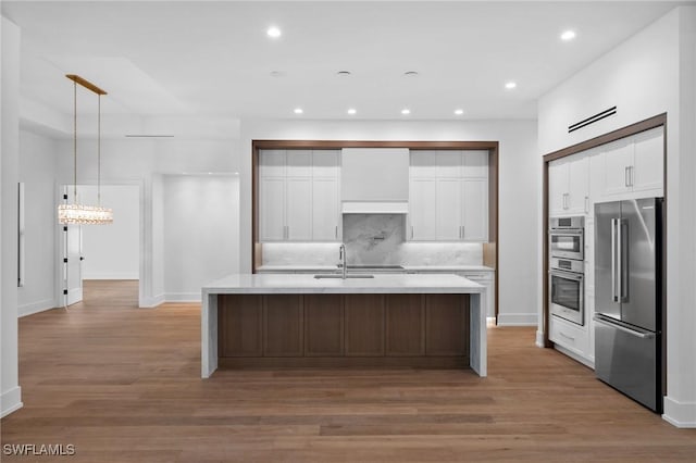3233 64th St SW, Naples, FL 34105 - kitchen featuring appliances with stainless steel finishes, backsplash, light countertops, light wood-style flooring, and white cabinets