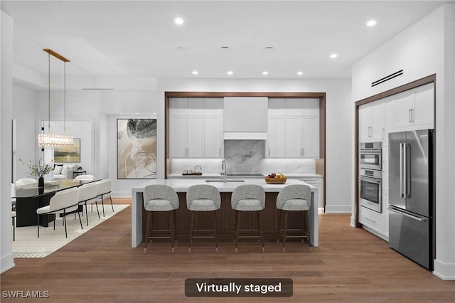 3233 64th St SW, Naples, FL 34105 - kitchen with appliances with stainless steel finishes, light countertops, tasteful backsplash, wood finished floors, and recessed lighting