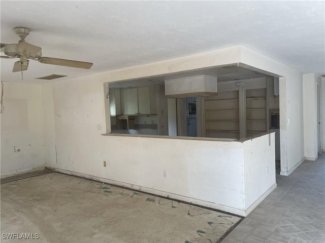 spare room featuring ceiling fan and baseboards