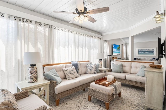 living area featuring a ceiling fan and ornamental molding