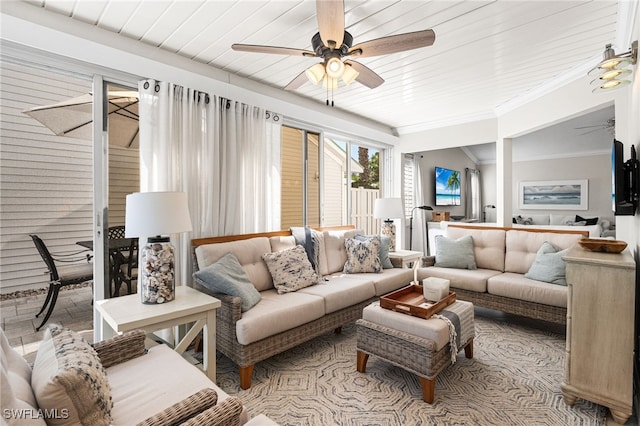 living area featuring a ceiling fan and crown molding