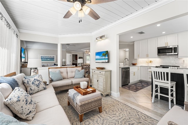 living room with visible vents, a ceiling fan, recessed lighting, crown molding, and light tile patterned floors