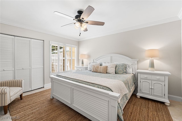 bedroom featuring ceiling fan, baseboards, a closet, and ornamental molding