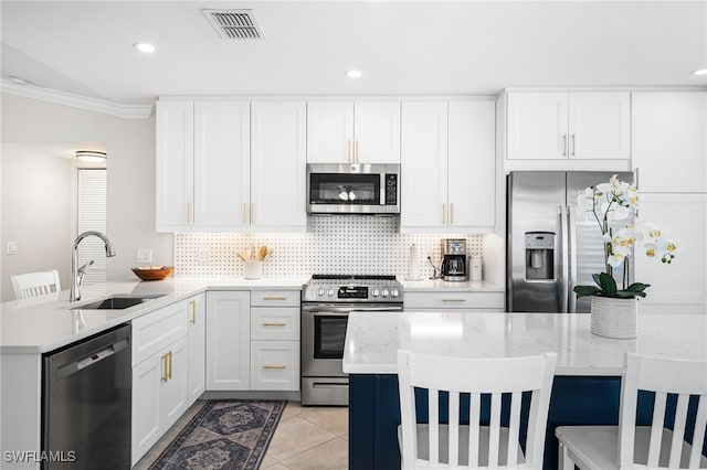 kitchen featuring visible vents, a sink, stainless steel appliances, a peninsula, and light tile patterned floors