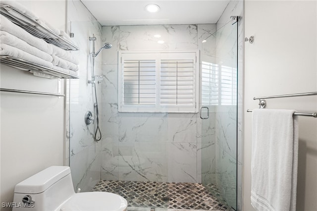 bathroom with a marble finish shower and toilet