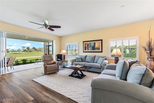 living room featuring a healthy amount of sunlight, ceiling fan, and wood finished floors