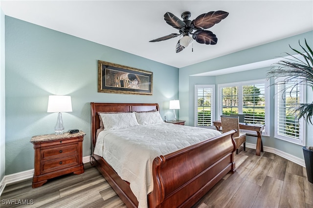 bedroom with ceiling fan, baseboards, and wood finished floors