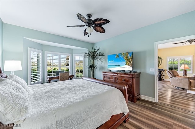 bedroom featuring a ceiling fan, baseboards, and wood finished floors