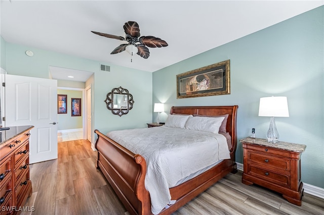 bedroom with baseboards, visible vents, ceiling fan, and light wood finished floors