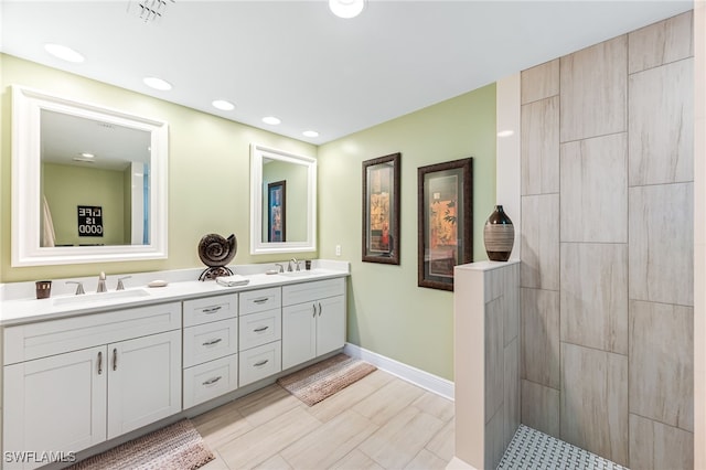 bathroom featuring double vanity, visible vents, baseboards, and a sink