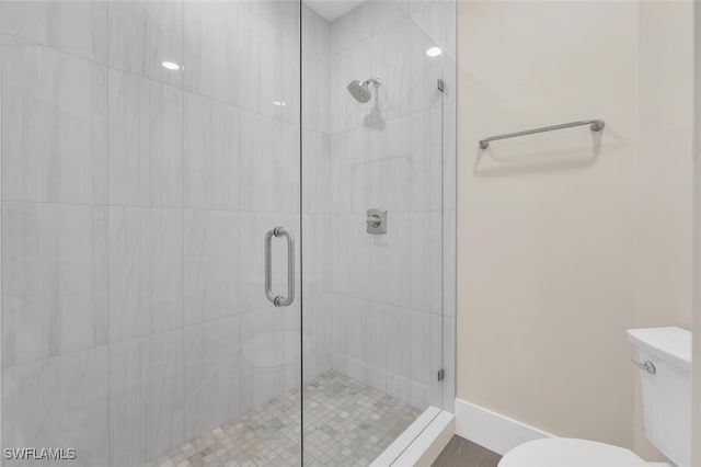 full bath with toilet, baseboards, and a stall shower