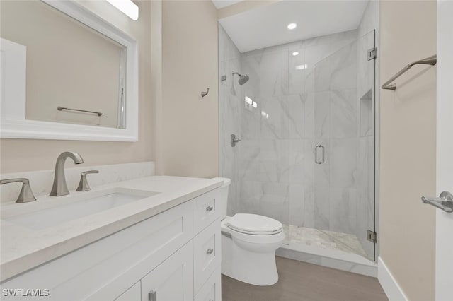 full bathroom with vanity, toilet, wood finished floors, and a stall shower