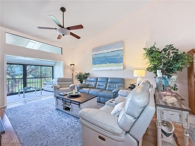 living room with a ceiling fan, vaulted ceiling, and wood finished floors