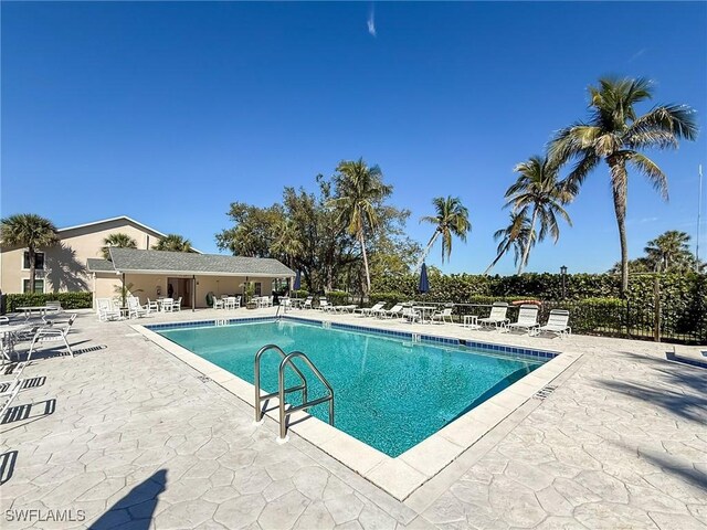 pool with a patio area and fence