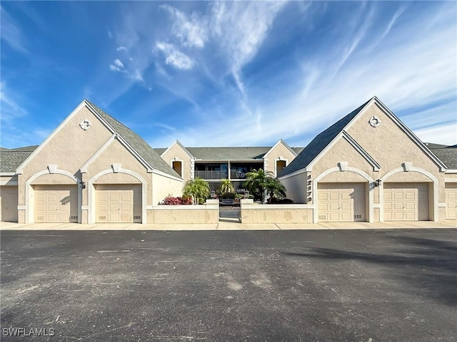 view of front of house with community garages and stucco siding