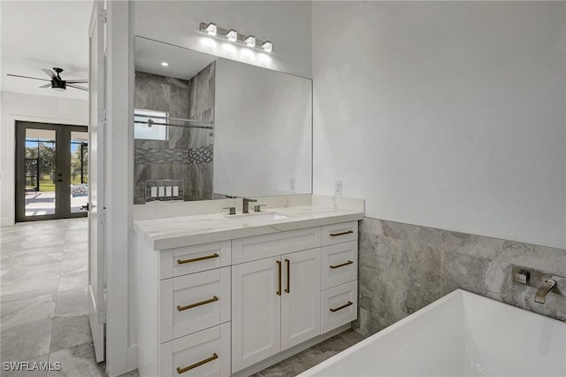 bathroom with vanity, a freestanding tub, a stall shower, ceiling fan, and french doors