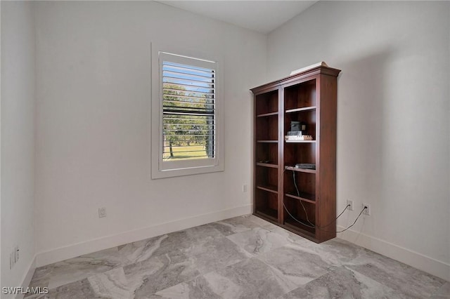 empty room featuring baseboards and marble finish floor