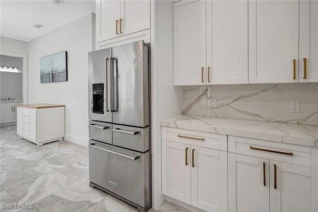 kitchen with visible vents, marble finish floor, high end fridge, tasteful backsplash, and light stone countertops