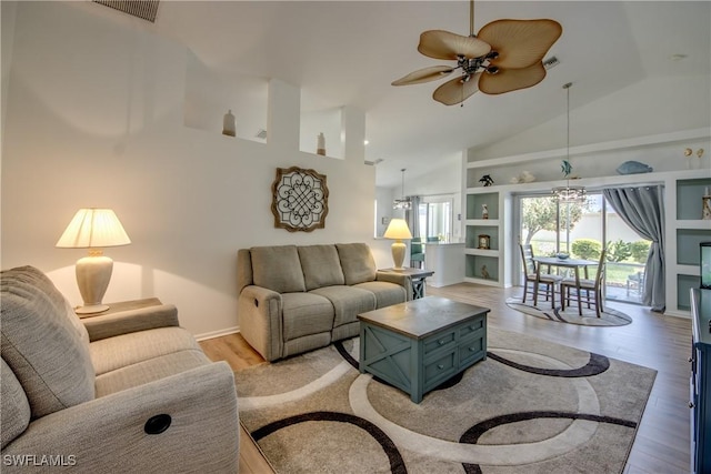 living area featuring built in shelves, lofted ceiling, visible vents, light wood-style floors, and ceiling fan