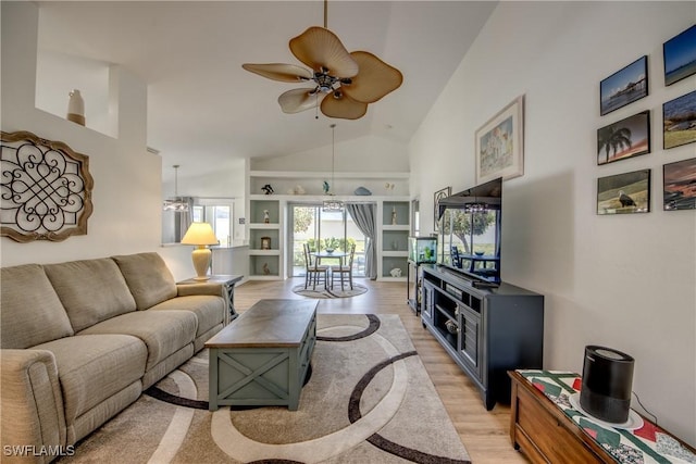 living room featuring ceiling fan, high vaulted ceiling, built in shelves, and light wood-style floors