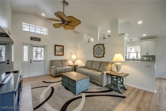 living room featuring light wood finished floors, visible vents, lofted ceiling, ceiling fan, and recessed lighting