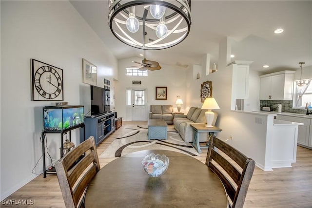 dining area with vaulted ceiling, light wood-type flooring, a ceiling fan, and recessed lighting