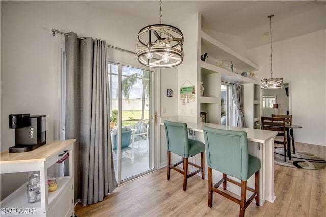 dining area featuring lofted ceiling, light wood-style flooring, and an inviting chandelier