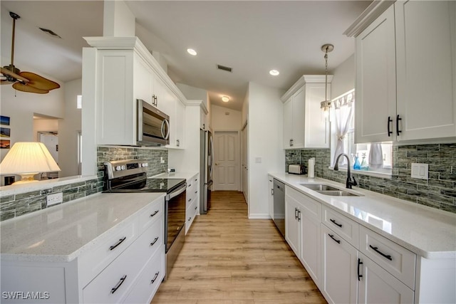 kitchen with light wood finished floors, visible vents, appliances with stainless steel finishes, white cabinetry, and a sink