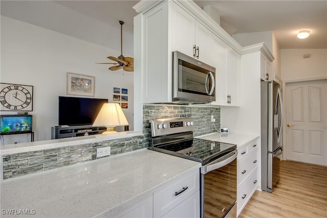 kitchen featuring stainless steel appliances, backsplash, light wood-style floors, white cabinets, and light stone countertops