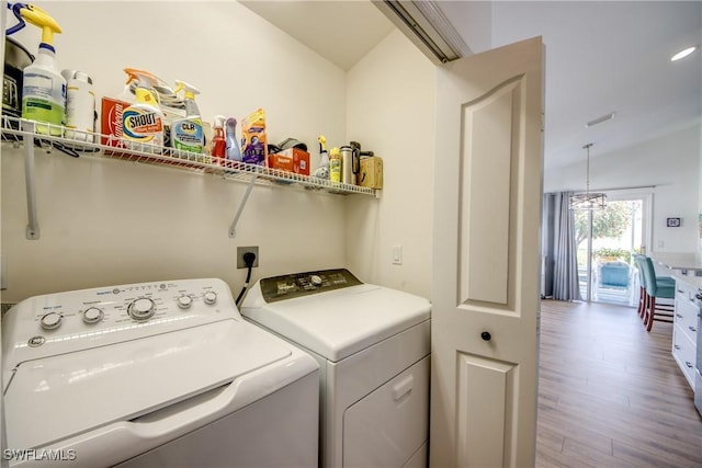 washroom featuring laundry area, washer and clothes dryer, and wood finished floors