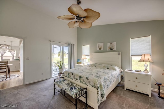 carpeted bedroom featuring access to outside, multiple windows, a ceiling fan, and baseboards