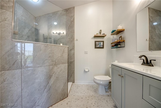 bathroom with a walk in shower, vanity, toilet, and baseboards