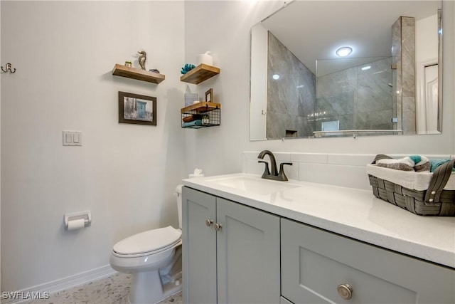 full bathroom with baseboards, a tile shower, vanity, and toilet